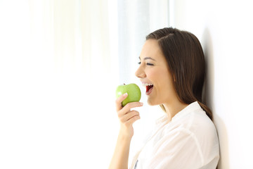 Wall Mural - Woman eating an apple isolated at side