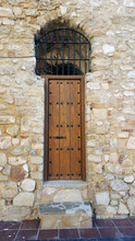 Heavy Studded Wooden Door To A Belltower Set In A Sandstone Wall.