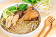 Braised chicken soup with bitter gourd noodle on wooden table.Selective focus.