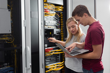 Team of technicians working together on servers at the data centre