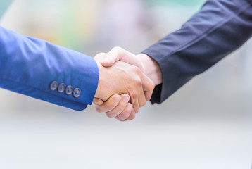 Businessmen making handshake on blurred background. Business partnership concept.