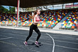 © AS Photo Family - Fitness sporty girl in sportswear at stadium outdoor sports. Happy sexy woman running on athletic track treadmill on stadium.