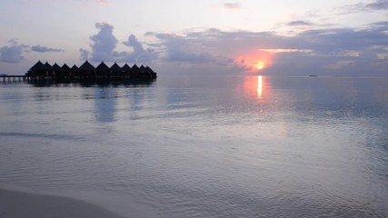 Wall Mural - Sunset over the luxury resort. Tropical island in the ocean. Maldives.