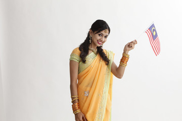 Wall Mural - Indian woman in traditional clothing holding flag