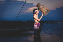 Fishing Man Use Bamboo Fish Trap To Catch Fish In Lake At Sunset