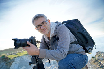 Portrait of photographer taking pictures in natural landscape