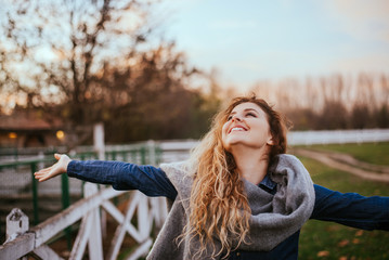 Freedom feel good. Joyful woman rising hands outside.