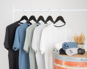 Wall Mural - Black,blue, grey and white t-shirts on hangers on gray background