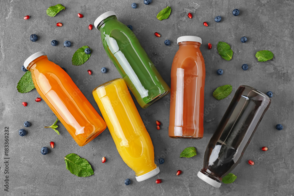 Composition with bottles of fresh juices on table