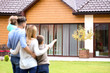 © Africa Studio - Happy family standing in courtyard and looking at their house