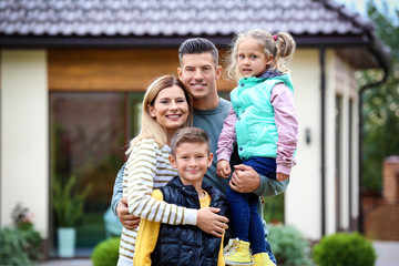 Happy family in courtyard near their house