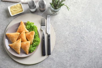 Poster - Plate with delicious baked samosas on table