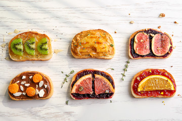 Wall Mural - Slices of bread with various toppings on light background