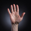© papa - The human hand in a gesture of welcome closeup on dark background.