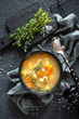 Fresh fish soup in bowl on dark background, top view