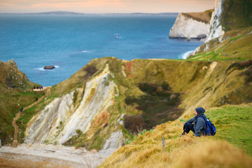 Tourist enjoying view of Man O'War Cove on the Dorset coast in southern England, between the headlands of Durdle Door to the west and Man O War Head to the east