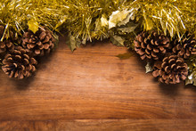 Traditional Christmas Background On Wooden Background With Golden Tinsel And Pine Cones