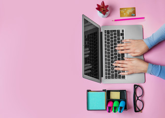 Wall Mural - Young woman using laptop for online shopping on color background