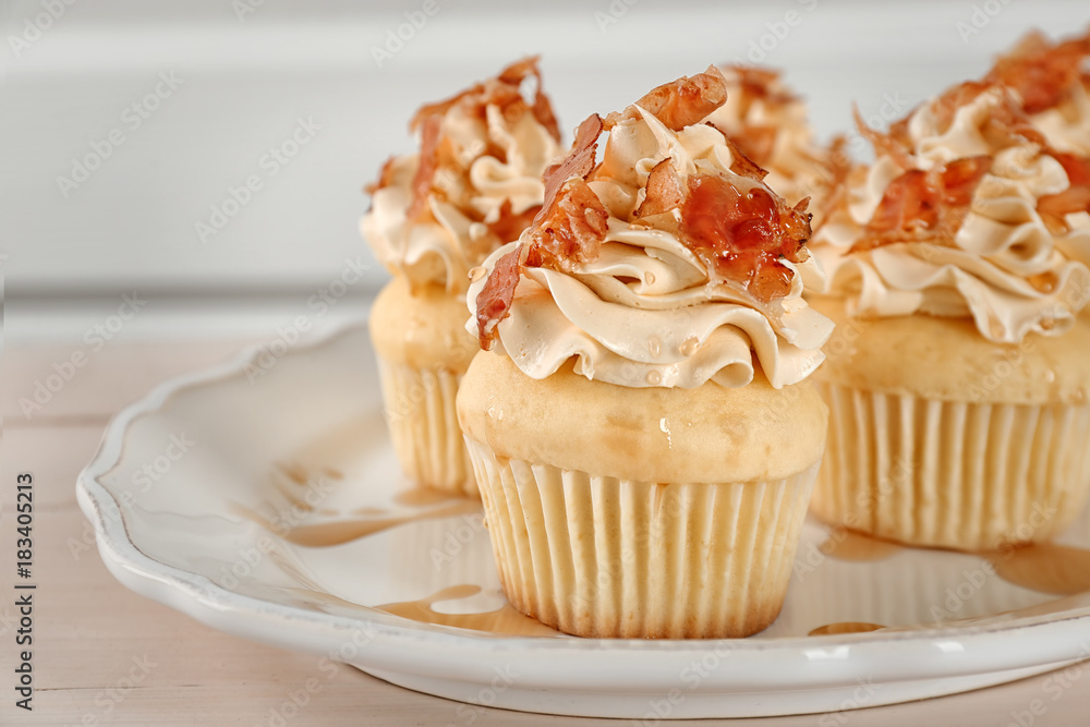 Tasty cupcakes with bacon on plate, close up
