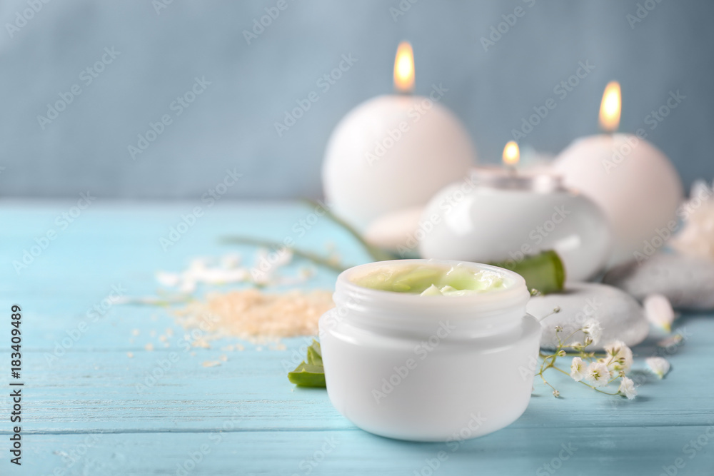 Jar with body cream on wooden table