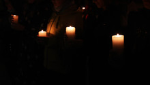 Crowd With Burning Candles On Dark Background