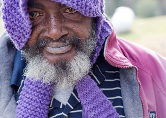 Elderly homeless man staring hopefully into camera 