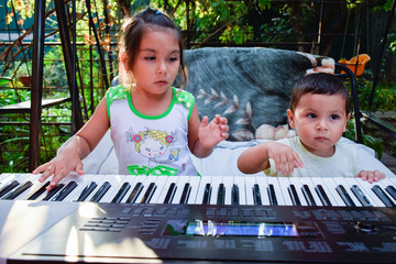 Latin little siblings playing electric piano