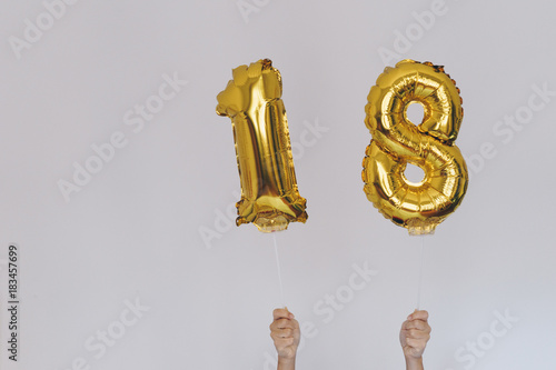 Photographie Hands holding golden 18 balloons, new year concept