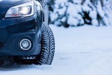 Winter Tire. Front View Of SUV Car With Headlights On.