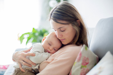 Sticker - Young mother, holding tenderly her newborn baby boy