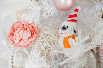 Wall Mural - the symbol of the new 2018 dog toy in front of a white decorated Christmas tree closeup