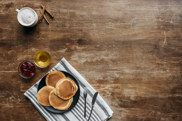 Wall Mural - top view of pancakes on striped napking and coffee cup on wooden table
