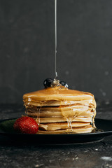 Wall Mural - close-up shot of maple syrup pouring onto stacked pancakes
