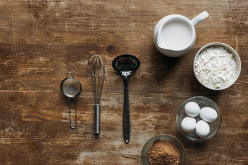 Wall Mural - top view of ingredients for pastry and utensils on wooden table