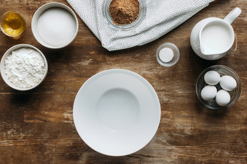 Wall Mural - top view of ingredients for pastry and empty bowl on wooden table