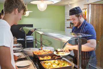 Wall Mural - Teenage Students Being Served Meal In School Canteen