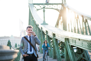 Wall Mural - Mature businessman with a smartphone in a city.