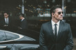 © LIGHTFIELD STUDIOS - bodyguard standing at businessman car and reviewing territory
