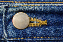 Brass Button Of Vintage Blue Jeans. Suitable For Backgrounds, Articles About Fashion Clothing.