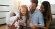 © NDABCREATIVITY - Family holding a tablet and looking at it