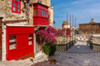 The traditional Maltese street with red phone box, shutters and balconies in Valletta, Capital city of Malta