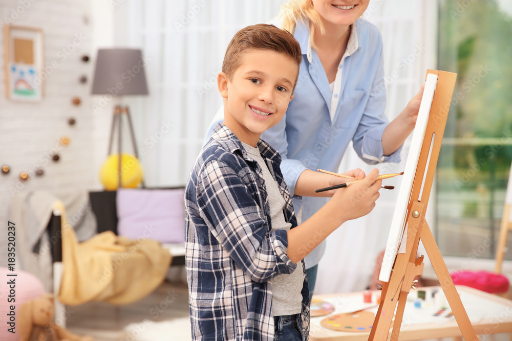 Little boy with mother painting at home