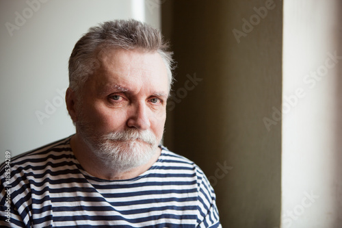Serious Adult Man With Grey Hair Looking Into The Camera