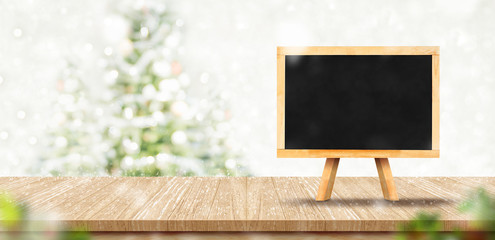 Leinwandbilder - Blank blackboard menu on wood plank table top with abstract blur christmas tree red decor ball and snow fall background with bokeh light,Holiday backdrop,Mock up banner for display of product