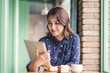 © makistock - Beautiful cute asian young businesswoman in the cafe, using digital tablet and drinking coffee smiling