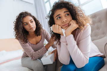 What should I do. Selective focus on an unhappy thought girl looking into vacancy while sitting next to her best friend and listening to the advice.