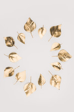 Close Up View Of Golden Leaves Arranged In Circle Isolated On Grey