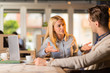 © Goran - Business colleagues talking to each other in the office.