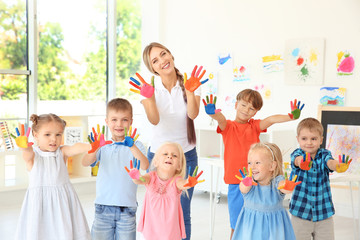 Poster - Children and teacher with hands in paint at art lesson