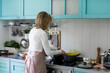 © LUMINA IMAGES - Back view of woman cooking spaghetti at home.